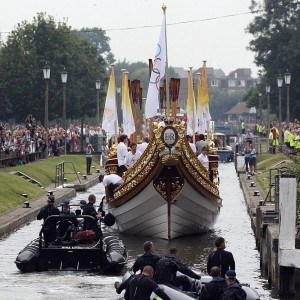 LONDON, ENGLAND - JULY 27: The Queen's rowbarge 'Gloriana' carries the Olympic flame along the river Thames from Hampton Court to City Hall on the final day of the London 2012 Olympic Torch Relay on July 27, 2012 in London, England. The Olympic flame is making its way through the capital on the final day of its journey around the UK before arriving in the Olympic Stadium tonight for the Olympic games' Opening Ceremony. (Photo by Oli Scarff/Getty Images)