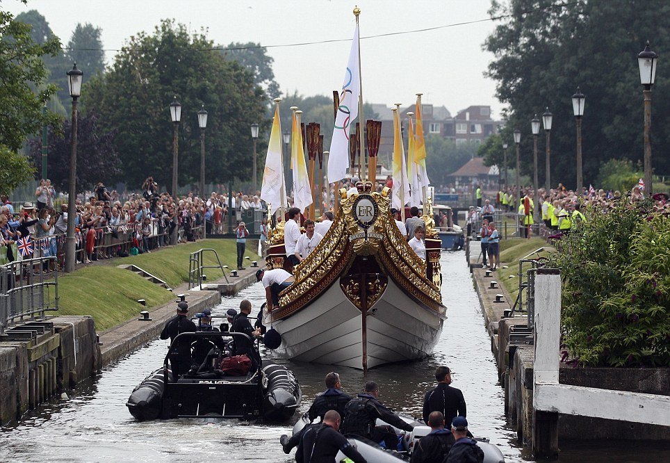 LONDON, ENGLAND - JULY 27: The Queen's rowbarge 'Gloriana' carries the Olympic flame along the river Thames from Hampton Court to City Hall on the final day of the London 2012 Olympic Torch Relay on July 27, 2012 in London, England. The Olympic flame is making its way through the capital on the final day of its journey around the UK before arriving in the Olympic Stadium tonight for the Olympic games' Opening Ceremony. (Photo by Oli Scarff/Getty Images)