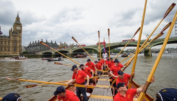 The crew of the Gloriana 'toss oars' as a salute to the Palace of Westminster