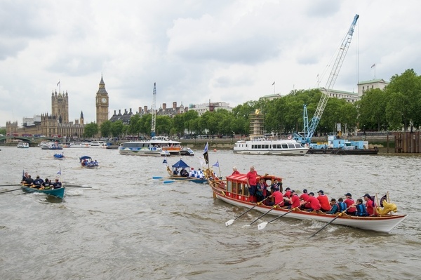 The small boat flotilla behind the Gloriana MV Gloriana rows up the Thames as part of HM The Queen's 90th Birthday celbrations