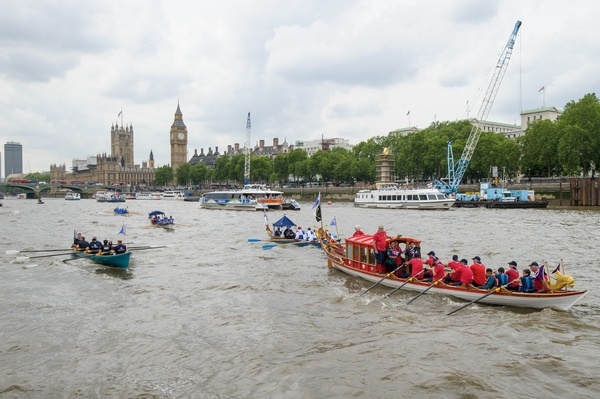 The small boat flotilla behind the Gloriana MV Gloriana rows up the Thames as part of HM The Queen's 90th Birthday celbrations